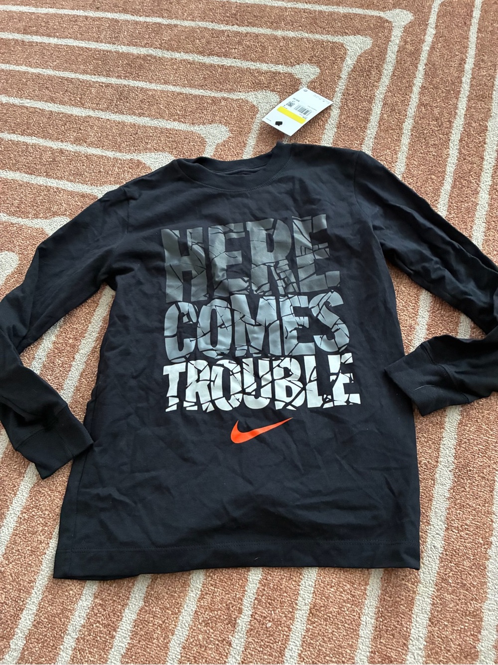 New Nike kids' long-sleeve graphic tee featuring a "Here Comes Trouble"
